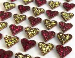 En bild som visar chokladhjärtan i mörk choklad med hallon och mjölkchoklad med hackade pistagenötter från Kalmar Chokladfabrik